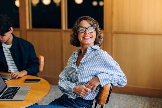 Smiling woman seated at a table in a coworking space