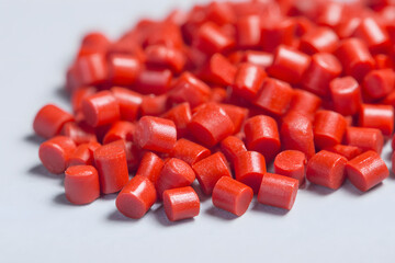 Vibrant Red Plastic Granules on White Background - Essential Raw Material for Polymer Production...