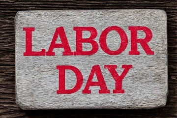 Labor Day text painted in red on an aged weathered wooden plank. Concept for workers appreciation holiday.