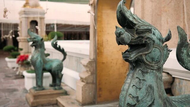 Bronze singha statue, a mythical lion like creature, stands guard at wat pho buddhist temple, Bangkok, Thailand.