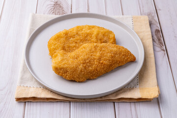 Milanese chicken breast over wooden table