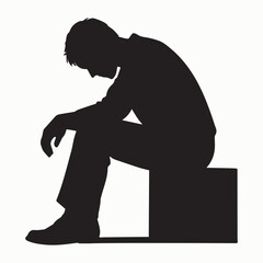Silhouette of a Man Overcome with Depression Seated on a Box in Despair and Isolation Expressing Sadness