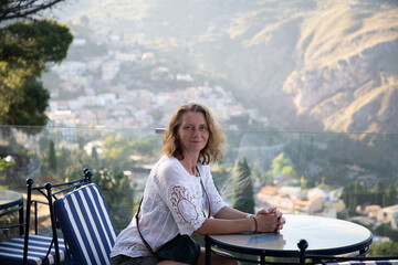 woman on terrace overlooking mountain towns