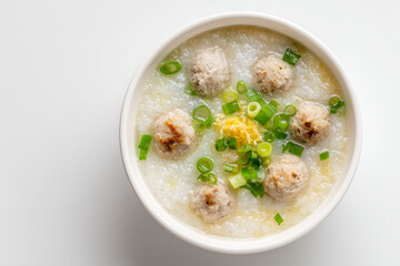Top view porridge bowl with spring onion, sliced ginger and meatball isolated on white background, Breakfast menu for Asian, Hot bowl of porridge with pork ball, Hot congee bowl.