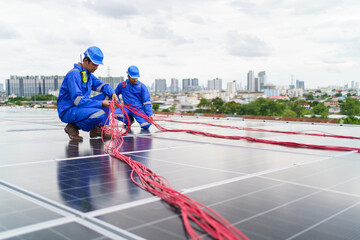 Electrical engineers are inspecting and installing a solar panels on the building rooftop.