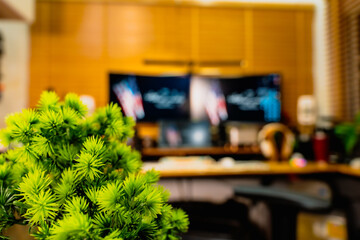 Modern home office desk setup with American Independence Day theme, including monitors displaying US flag wallpaper, bonsai tree, microphone, and warm cozy lighting ambiance.