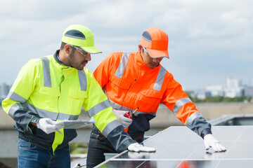 Electrical engineers are inspecting and installing a solar panels on the building rooftop.