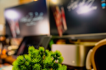 Modern home office desk setup with American Independence Day theme, including monitors displaying US flag wallpaper, bonsai tree, microphone, and warm cozy lighting ambiance.