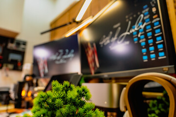 Modern home office desk setup with American Independence Day theme, including monitors displaying US flag wallpaper, bonsai tree, microphone, and warm cozy lighting ambiance.