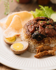 Indonesian Braised Beef with Rice, Marinated Egg, and Crackers – Traditional Comfort Food on White Plate, Spiced Beef Stew on Rice with Eggs and Crackers – Asian Comfort Food, Authentic Indonesian Ric