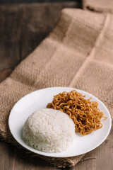 Plate of White Rice and Fried Instant Noodles on Rustic Burlap Background – Traditional Indonesian Comfort Food, Simple Home-Cooked Asian Meal – Rice and Mie Goreng on Plate, Indonesian Street Food 