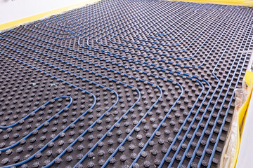 System of underfloor heating. Installation of a heat flooring system. Modern heating system in a...