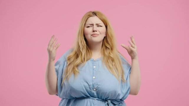 Plus size woman rolls eyes and makes blah-blah gesture, bored facial expression