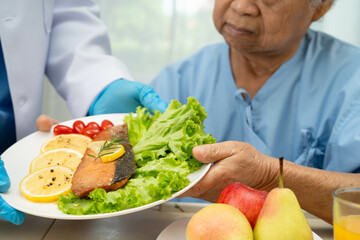 Asian Nutritionist holding healthy food for patient in hospital, nutrition and vitamin.