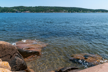 Rocky coastal waters at Berger, Svelvik with distant green hills
