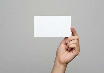 Fototapeta premium Blank white card mockup held in hand for business card design template and presentation background image