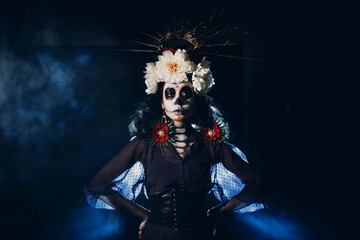 Woman with mexican skull halloween makeup on face. Day of the dead aka Dia de los Muertos and...