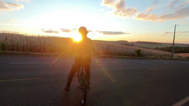 homem ciclista anda de bicicleta no p&ocirc;r do sol 