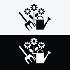 Watering can with flowers and pitchfork isolated on white background