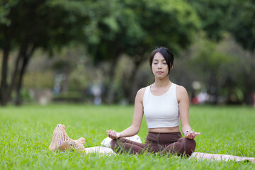 Sport woman practicing meditation and mindfulness at park