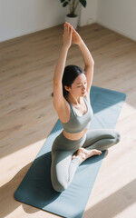 A woman wearing yoga clothes doing yoga movements forming beautiful and aesthetic movements, camera angle from above