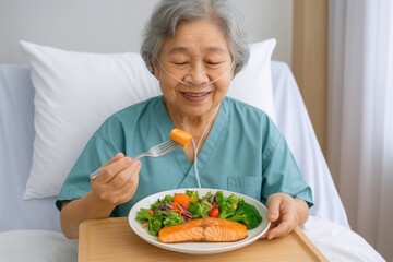 Senior woman eating in hospital, Elderly Asian woman with nasal cannula smiles while eating healthy meal of salmon and vegetables on hospital bed. Nutrition and recovery support in healthcare concept