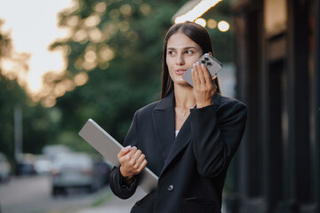Elegant business woman send a voice message in the city