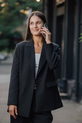 Elegant business woman talking by smartphone in the city