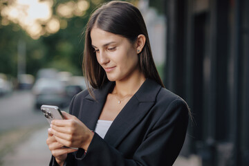 Business woman using smartphone at city street