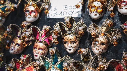 Colorful carnival masks displayed in a shop in Venice during daylight hours