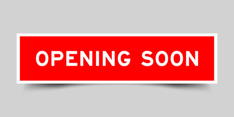 Red color square shape sticker label with word opening soon on gray background