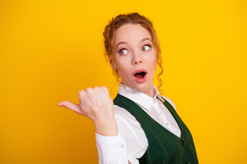 Excited young woman gesturing surprise on a bright yellow background fashionable student with red...