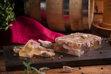 Jellied meat on a dark wooden board in the kitchen