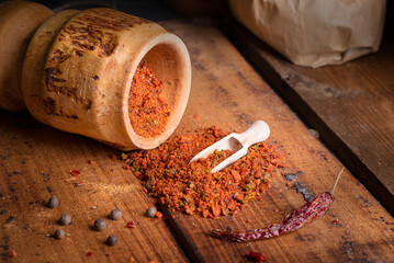 Crushed spices on wooden table among greens, vegetables
