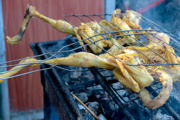 Chicken Cooking on Grill Over Charcoal with Smoke