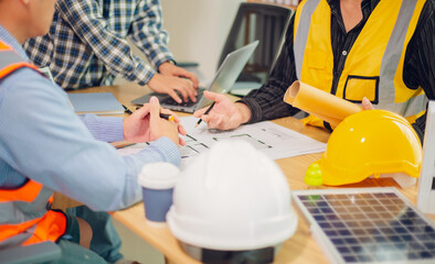 Engineers and architects discuss and consider construction plans for new renewable energy project...