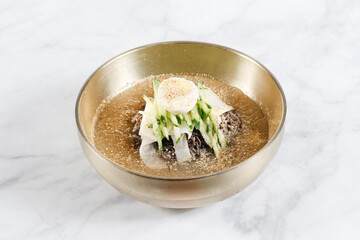Cold Buckwheat Noodles (Korean cool noodles) decorated on thet marble table.