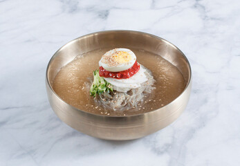 Cold Buckwheat Noodles (Korean cool noodles) decorated on thet marble table.