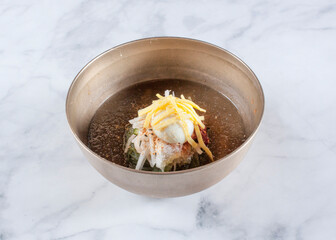 Cold Buckwheat Noodles (Korean cool noodles) decorated on thet marble table.