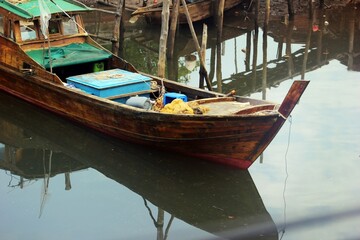 Tranquil Waters: A Wooden Fishing Boat's Reflection