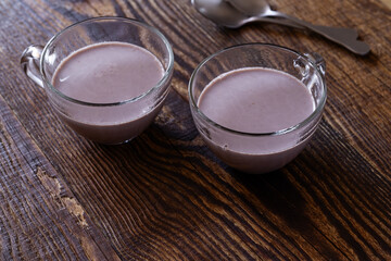 Hot chocolate in glass mug on wooden background