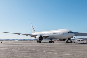 White wide body passenger aircraft at the jetwalk on the airport