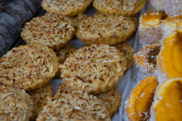 Delicious sweet pastries on a tray. Doughs filled with cream and sugar.