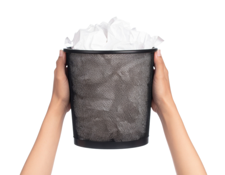 Hands holding a black mesh wastebasket filled with crumpled white paper.
