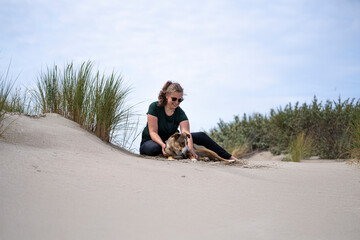 woman and girl sitting in the dunes