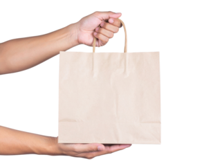 A person holds a plain brown paper shopping bag by the handles with one hand and supports it from below with the other hand.