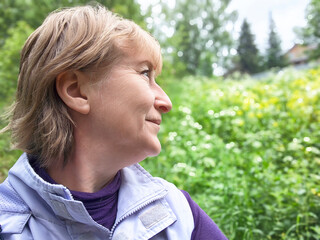 Mature blonde woman enjoying nature during a travel excursion on a summer day