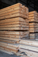 Stacked wooden planks close-up at lumber warehouse. Wood industry concept