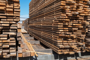 Stacked wooden planks close-up at lumber warehouse. Wood industry concept