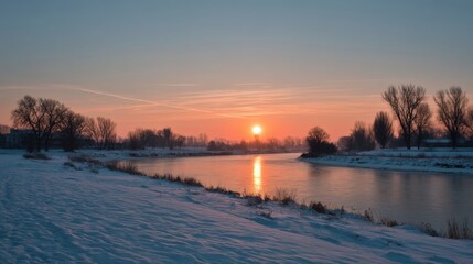 Obraz premium Winter river reflecting sunset with snow-covered banks and bare trees